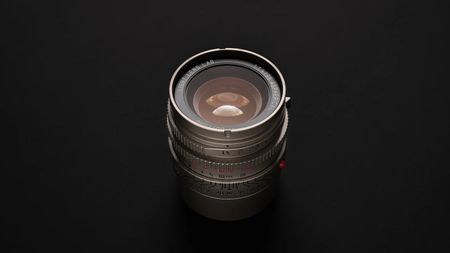 The Light Lens Lab 35mm f/1.4 Aspherical "11873" lens on a black studio background