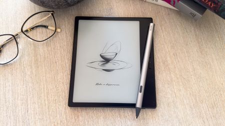 The Boox Go 7 ereader with the InkSense Plus stylus on a tablet beside a pair of spectacles